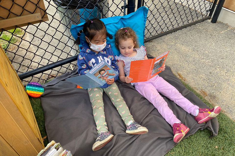 Two children read outside