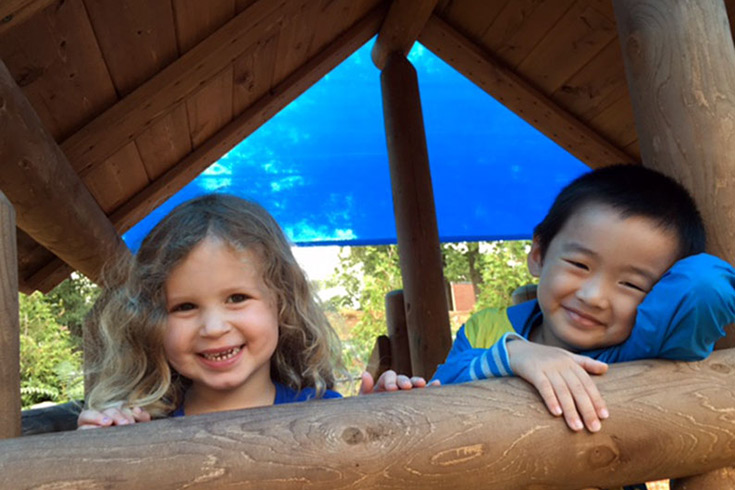 Two happy toddlers on a playground structure